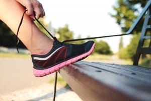 1-woman-tying-sports-shoe-on-bench