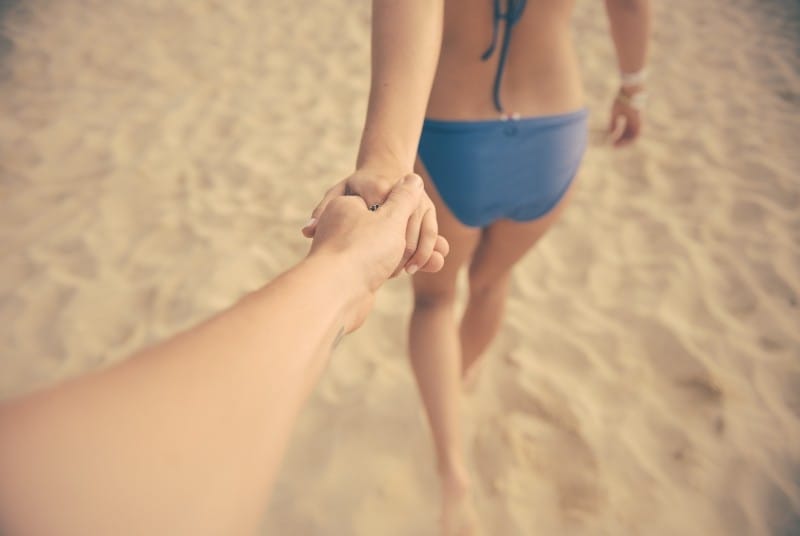 young-couple-holding-hands-and-walking-on-beach